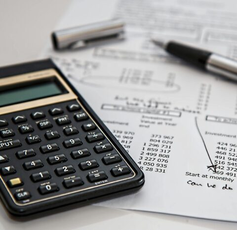 Close-up of financial documents with calculator and pen, ideal for business management themes.
