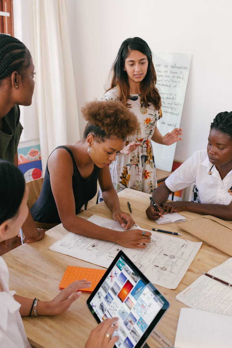 Group of women collaborating on a creative project in a modern office environment.